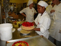 pastry chef student holding a cake