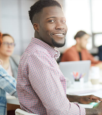 smiling man at a business meeting looking over shoulder
