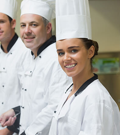 Smiling chefs in kitchen setting